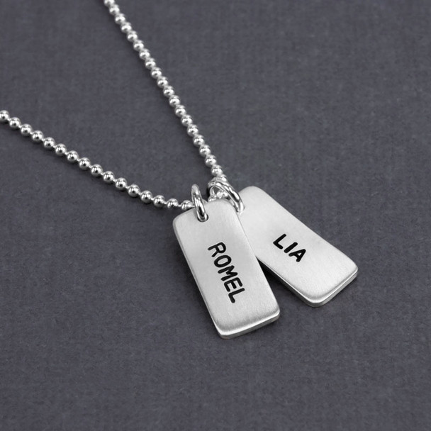 Angle view of Custom silver Chunky Rectangle Charms Necklace, personalized with hand stamped kids' names Romel and Lia