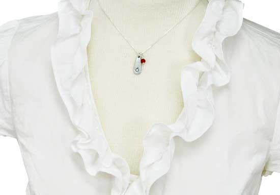 Thank you teacher gift. A  silver chain necklace with a teardrop shiny pewter charm and a red faceted birthstone representing an apple. Shown on a model