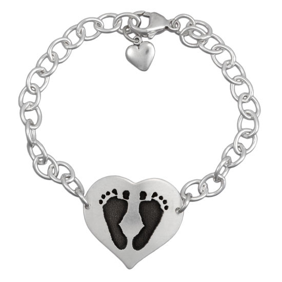 Custom silver heart bracelet personalized with your child's actual footprints, shown on white