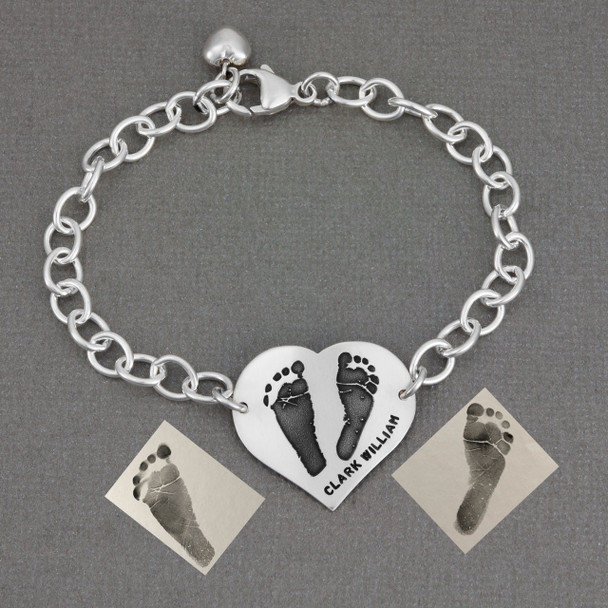 Custom silver heart bracelet personalized with your child's actual footprints, shown with original footprints