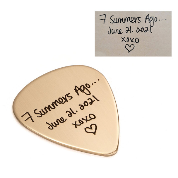 Side view of anniversary present of gold guitar pick with spouse's actual handwriting, shown on with original handwriting used to personalize the pick