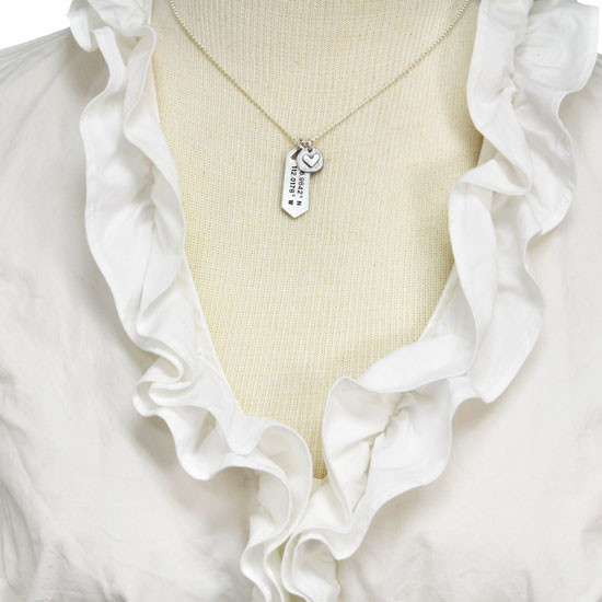 Hand stamped coordinates personalized silver necklace, shown on a model