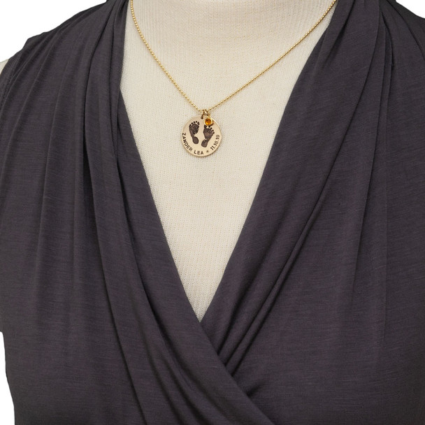 Model wearing custom footprints necklace in gold with hand stamping & birthstone