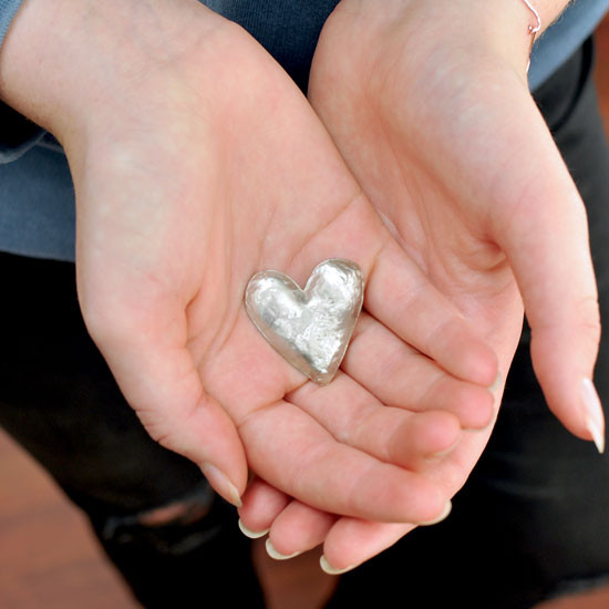 Personalized heart pocket token with handwriting, with rounded side up, held in hands