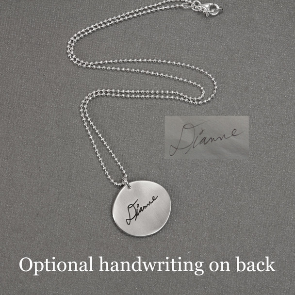 Handwriting engraved on back of silver memorial handwriting necklace, shown with original writing used to personalize it