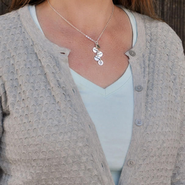 Model wearing custom Thai silver charm cascade necklace, personalized with hand stamped kids names