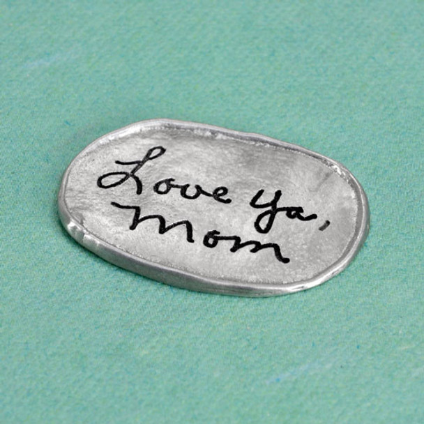 Handwritten signature from Mom on personalized memorial fine pewter oval pocket charm, shown from the side