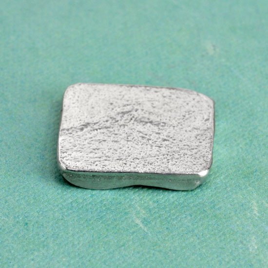 Square Handwriting Pocket Token made from fine pewter, shown from the back at an angle 