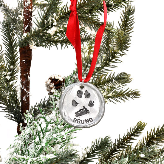 Custom fine pewter Christmas ornament, personalized with your dog or cat's pawprint, shown on a Christmas tree