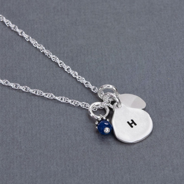 Back of handmade silver Luv U Always necklace, with initial stamped on the back