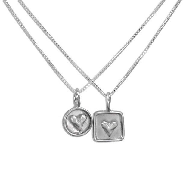Personalized silver heart necklaces, one with a raised heart on a silver circle frame, the other with a raised heart on a silver square frame. Both necklaces shown on white background.