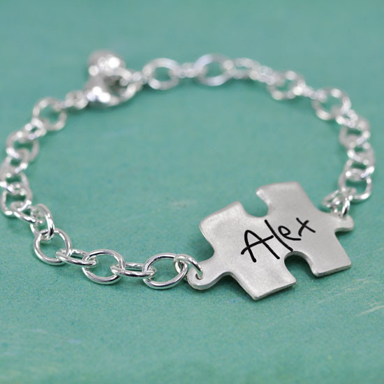Side view of custom silver puzzle piece handwriting bracelet, personalized with child's signature