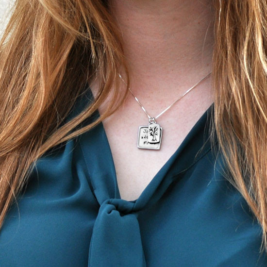 Model wearing handmade square pendant handwriting necklace, custom engraved with kids' handwritten signatures, and with silver family tree charm.