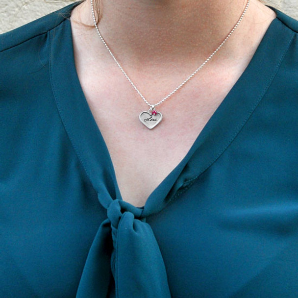 Sterling silver small heart for custom handwriting on necklace with birthstone, shown close up on white. shown on a model