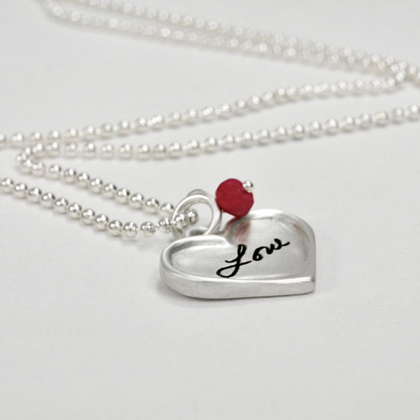 Sterling silver small heart for custom handwriting on necklace with birthstone, shown close up from the side