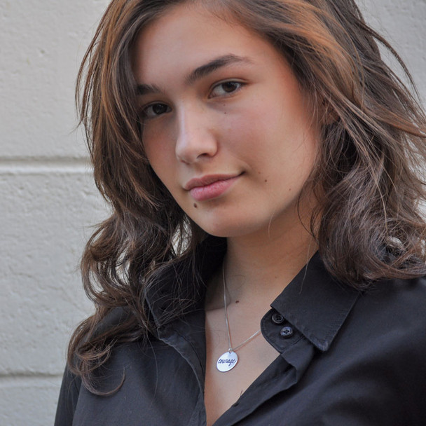 Model wearing sterling silver Cure for PANDAS necklace, with the message "Courage"