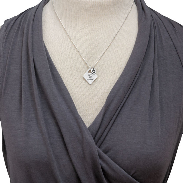 Model wearing personalized diamond shaped silver pendant, custom engraved with loved one's handwritten note, with silver heart charm