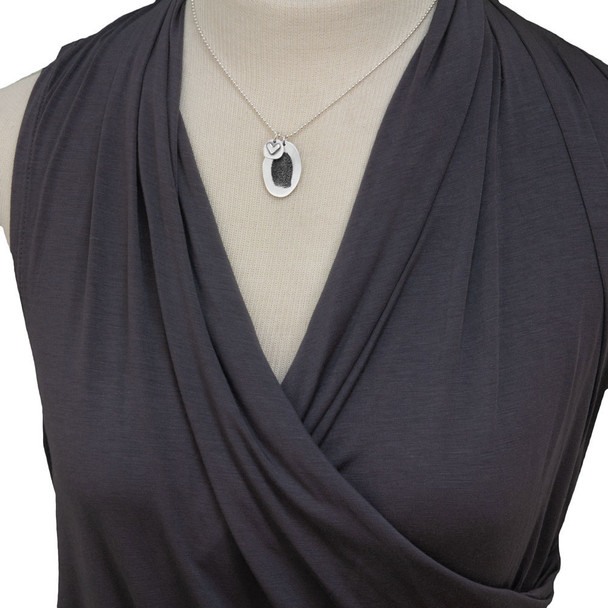 Custom silver fingerprint jewelry with silver heart shown on model