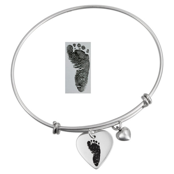 Custom adjustable silver charm bracelet with silver heart charm with child's actual footprint engraved on it, shown with the original footprint used to personalize it, along with a puffed silver heart charm. On a white background