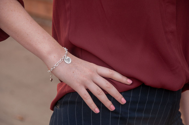 Model wearing custom silver fingerprint charm bracelet 