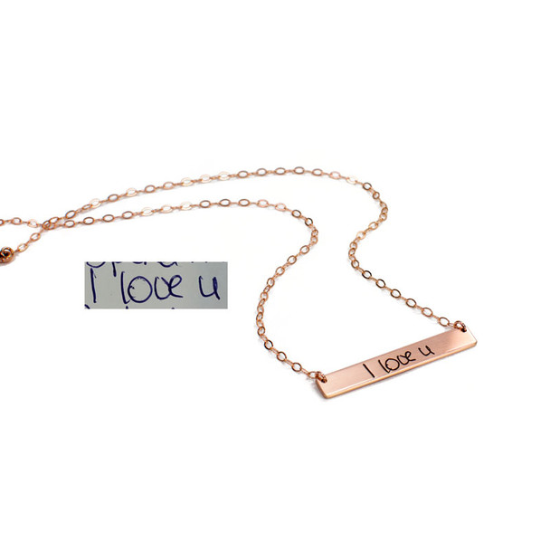 Side view of rose gold handwriting bar necklace, custom engraved with words, "I luv U", shown on white with original handwriting used to personalize it