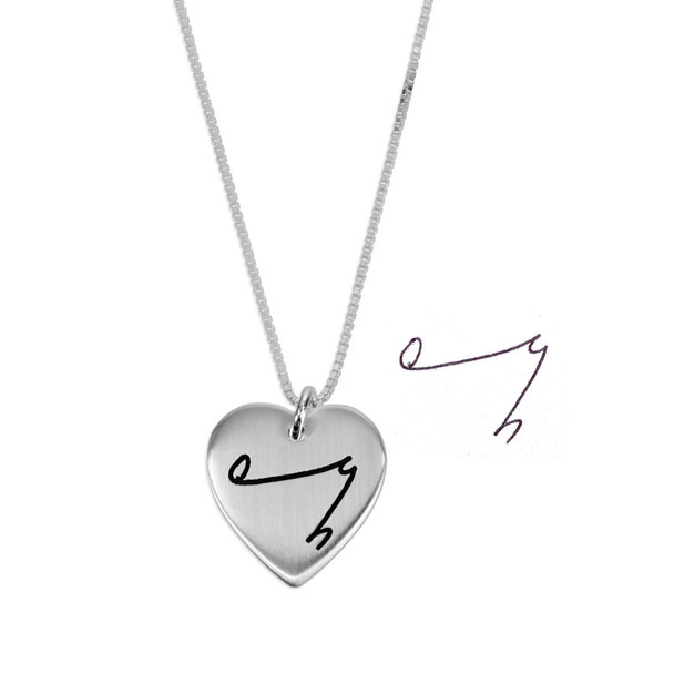 Custom silver heart necklace, engraved with son's special symbol for "I Love You", shown on white with the handwriting used to personalize it
