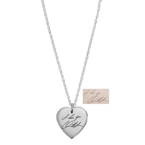 Wide view of custom silver heart necklace, engraved with husband's handwritten signature, shown on white with the handwriting used to personalize it
