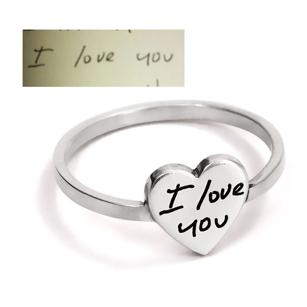 Custom Silver handwriting ring, with handwriting engraved on a silver heart, shown with the husband's actual handwritten "I Love You" used to personalize it. Shown close up on white