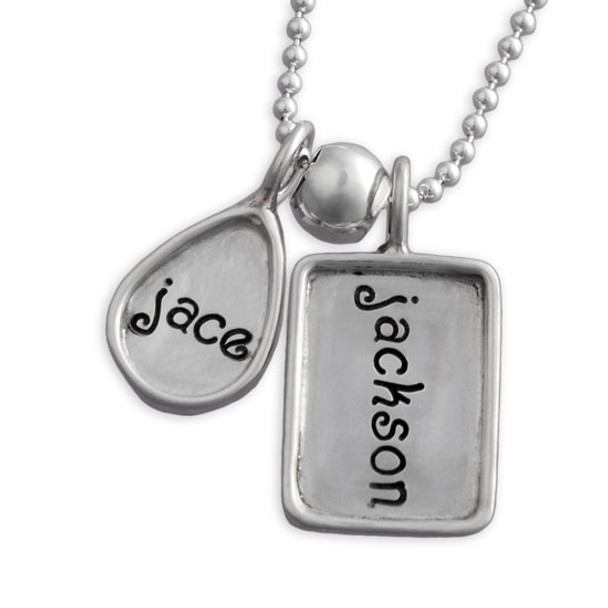 Sterling silver hand stamped raised edge tear drop charm with rectangle raised edge charms on a necklace, shown close up on white