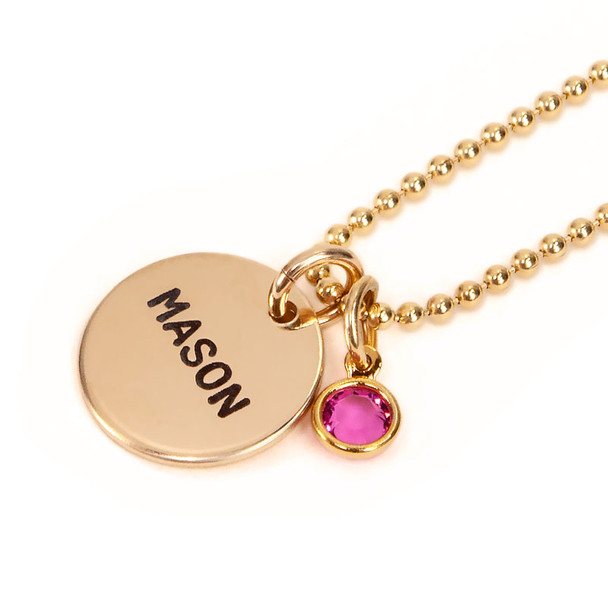 Hand stamped custom Gold Name Discs necklace personalized with a birthstone and kid's name, shown from the side on white