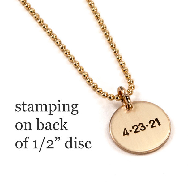 Stamped date on back of custom Gold Name Discs necklace, shown on white
