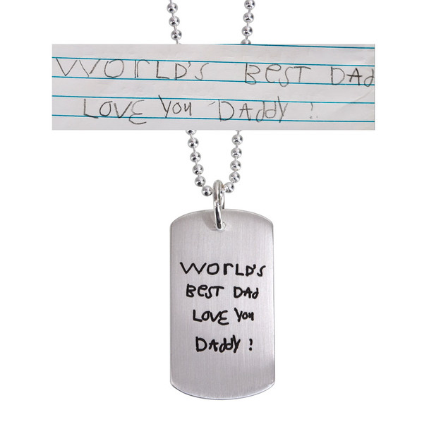 Custom silver dog tag necklace with child's handwriting, with the original handwritten note used to create it, shown on white
