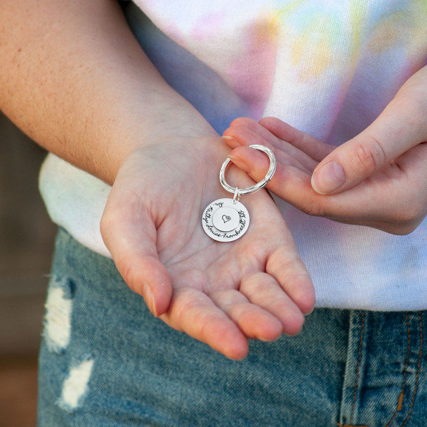 Custom Large Double Disc Key Ring in sterling silver, stamped with names and symbols, shown in hands