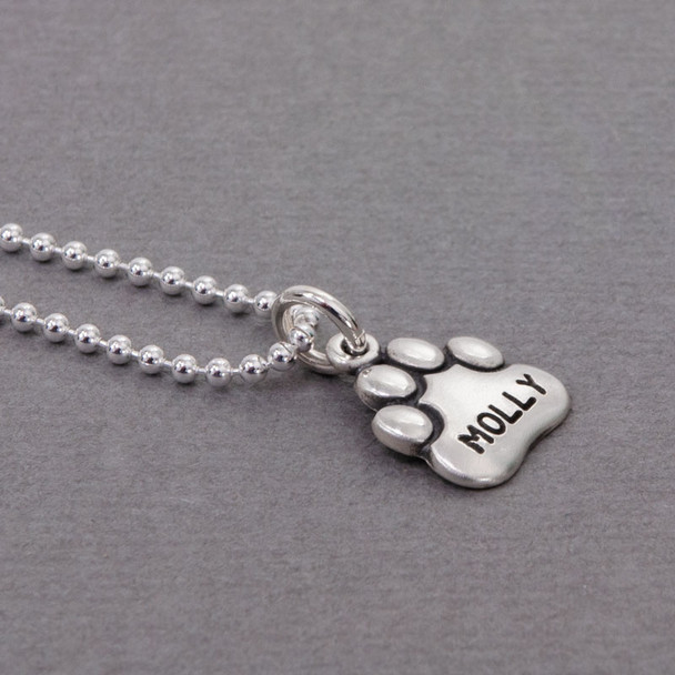 Side view of Large Sterling Paw Charm with name Molly stamped on it, shown on sterling silver chain