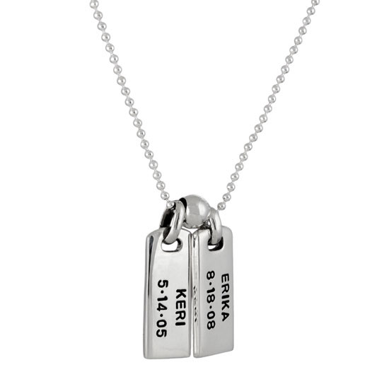 Wider view of two custom silver rectangle pendants, personalized with kids' names Keri and Erika hand stamped on the charms, along with the kids' birthdays. Shown on a silver chain, separated by a sterling spacer bead. Shown on white
