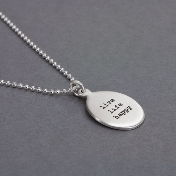 Side view of custom sterling silver oval charm necklace, personalized with stamped inspirational phrase using Typewriter Lower Case font