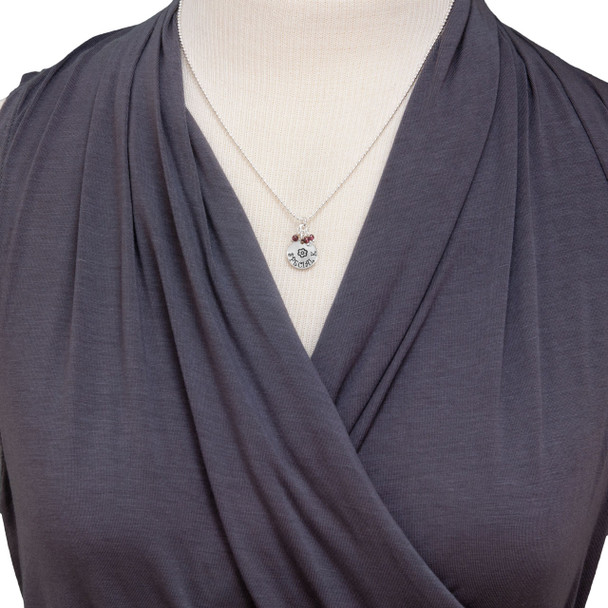 Model wearing custom sterling silver disc with stone cluster, personalized with hand stamped flower & child's name, and amethyst stones.