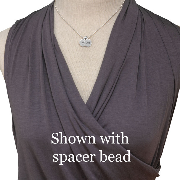 Sterling Name Discs with kids names hand stamped with Block Upper font on 1/2" silver circle charms, shown on model