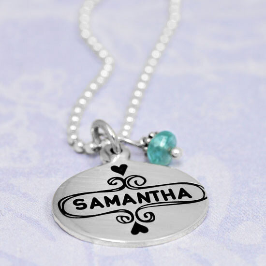 Side view of silver Sweet Frame oval charm necklace personalized with daughter's name stamped in the middle, hung with blue apatite stone