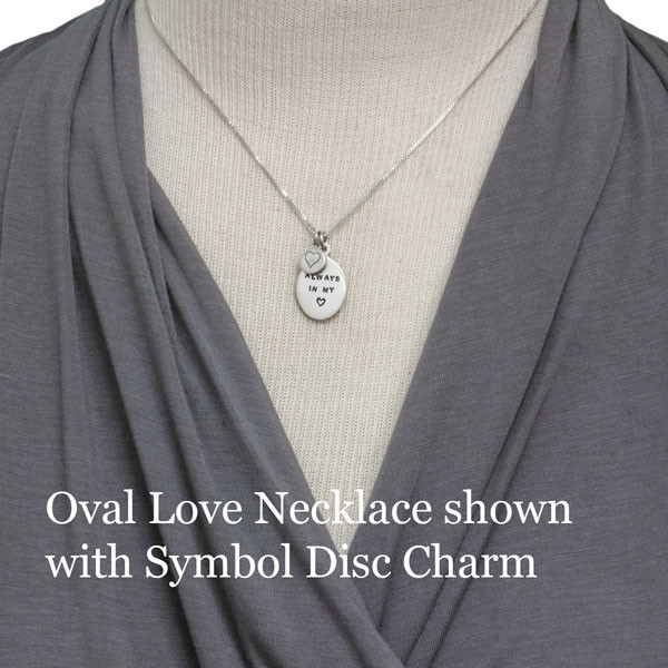 Model wearing silver Oval Love Necklace with added silver symbol disc charm with a heart