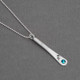 Angled view of fine silver custom Zodiac Pendant, personalized with zodiac symbol & matching blue birthstone