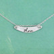Custom Silver Memorial signature necklace, personalized with loved one's handwriting, shown on green