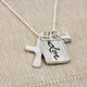 Silver charm with raised edge & the handwritten word Love, with a fine silver cross and fine silver heart, shown from the side