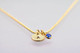 Custom Hand Stamped Gold initial birthstone necklace, personalized with child's initial & blue birthstone, shown from the side