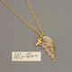 gold angel wing with handwriting, shown with original handwritten note used to personalize it