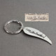 Personalized silver angel wing key ring with your loved one's handwriting, shown with the original handwritten note