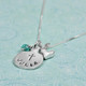 Side view of custom silver necklace for first communion, stamped with the name "Julia", with silver heart charm and birthstone