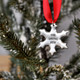 Custom Hand stamped fine pewter snowflake ornament, personalized with your message, shown on Christmas tree