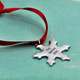 Custom Hand stamped fine pewter snowflake ornament, personalized with your message, shown on green