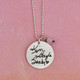 Personalized silver necklace for Mom, customized with 3 daughters' handwritten signatures on a 7/8" silver disc, hung with Opaque Pink Crystal Saucer Stone for June, on a silver ball chain, shown on pink background